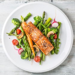 Bird’s eye view of grilled salmon and vegetables on a white plate