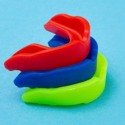 Red, blue, and green mouthguards stacked on each other