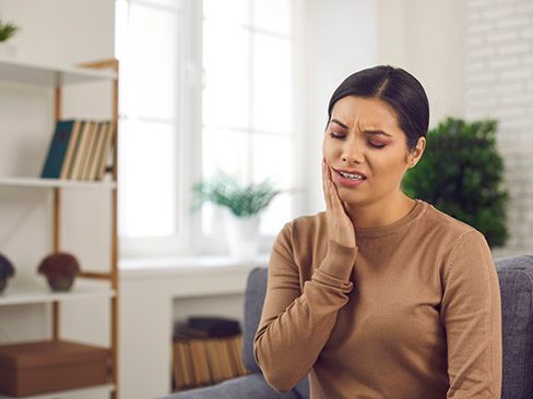 Woman experiencing toothache at home