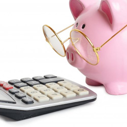 Close-up of calculator and piggy bank with glasses